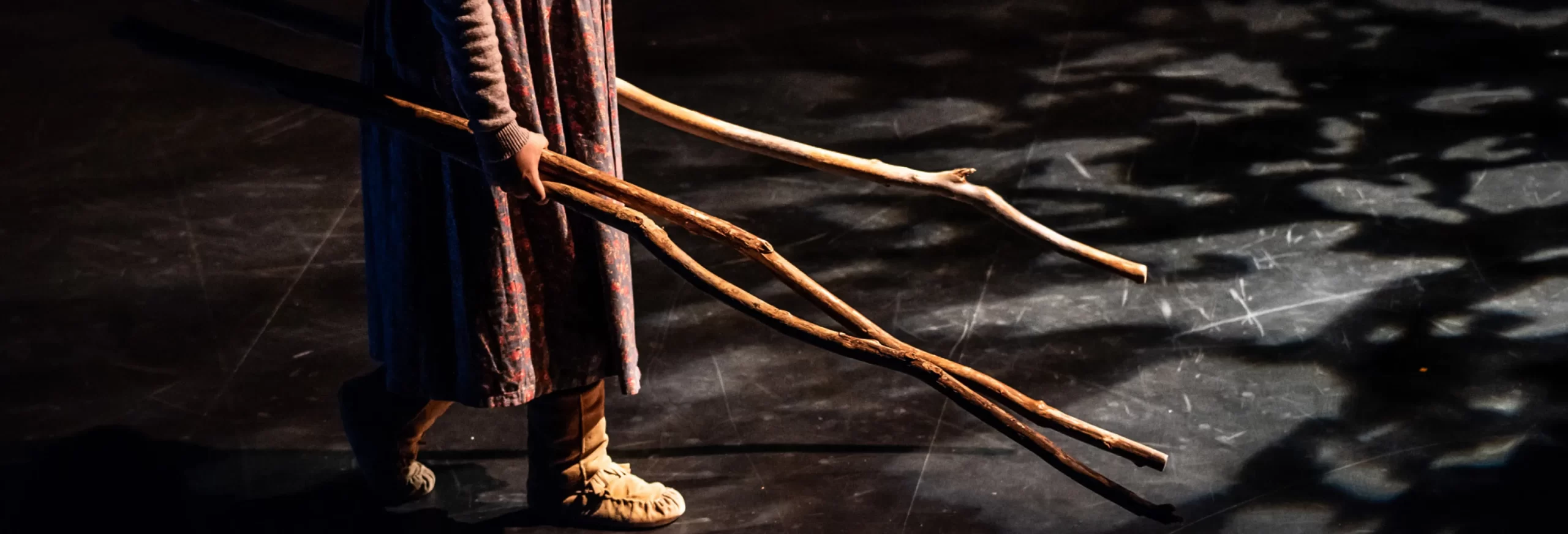 two dancers reaching arms towards each other on a stage