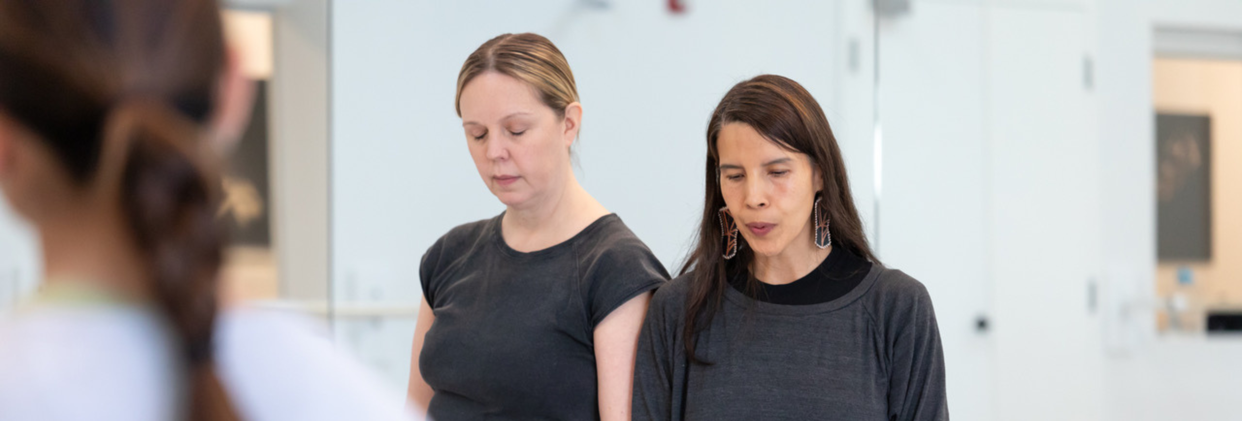 two dancers reaching arms towards each other on a stage