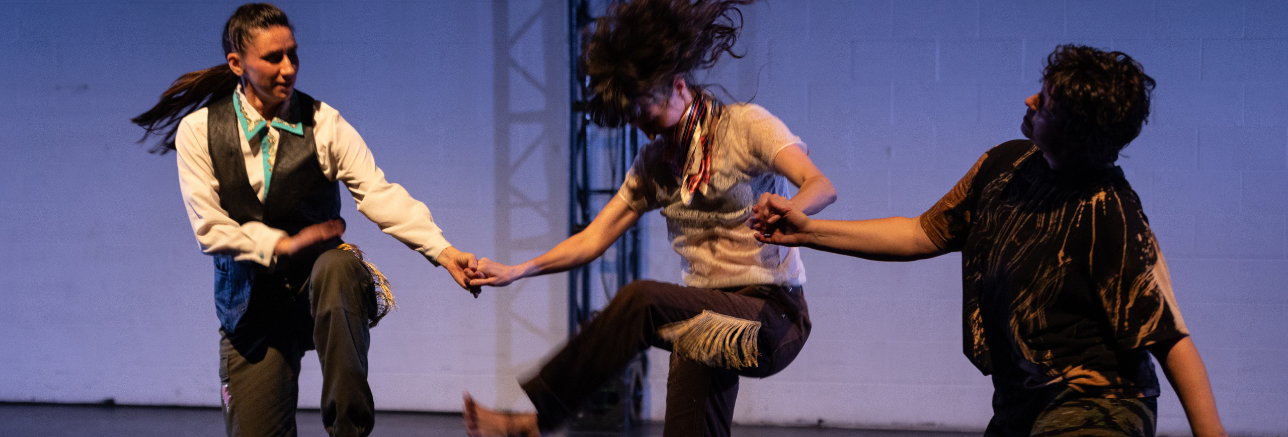 two dancers reaching arms towards each other on a stage